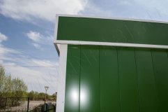 Крышу обрамляет декоративный козырек зеленого цвета с белой окантовкой